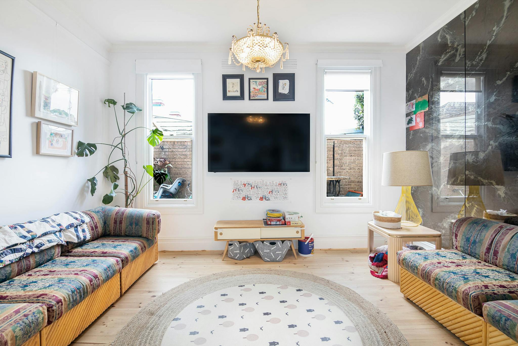 Spacious living room in Melbourne with contemporary design, featuring colorful sofas and elegant lighting.